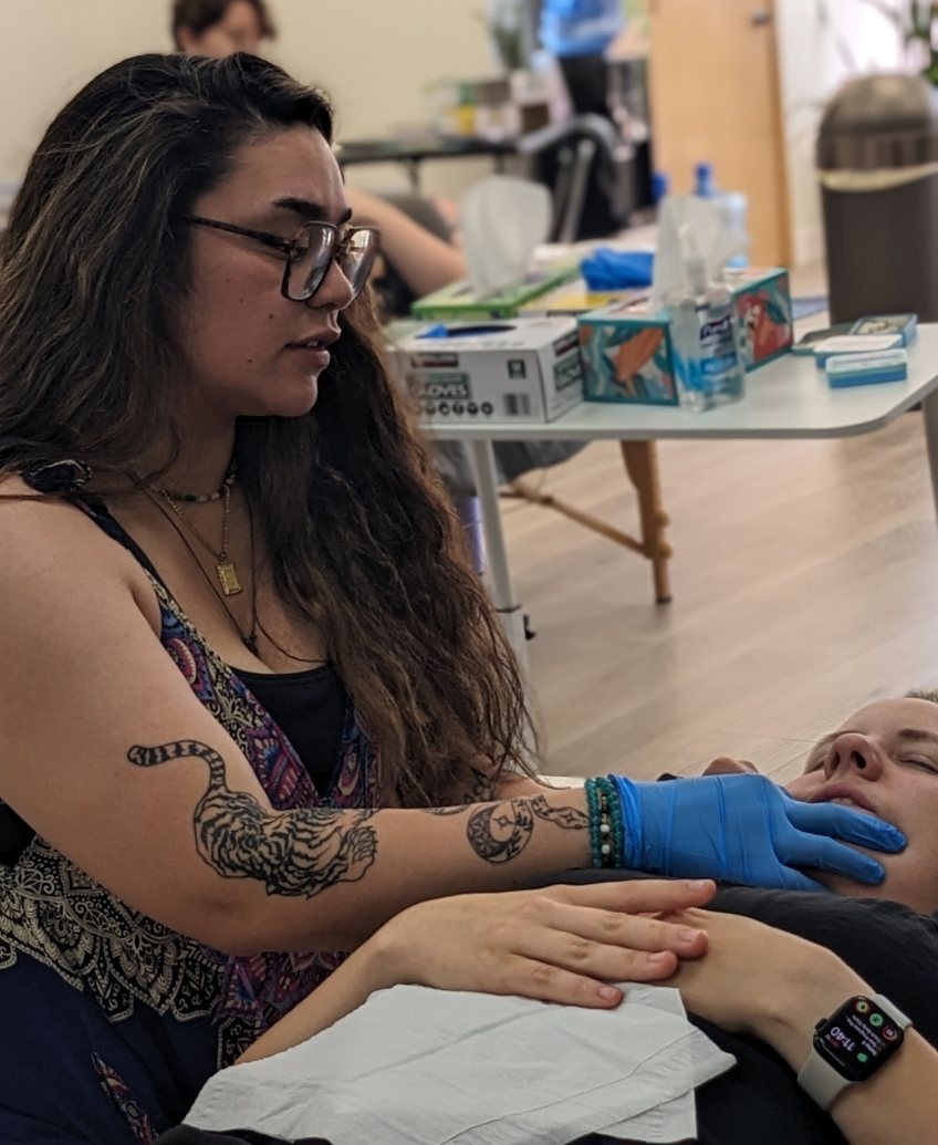 Valerie performing gloved jaw and TMJ work on a client lying on a treatment table